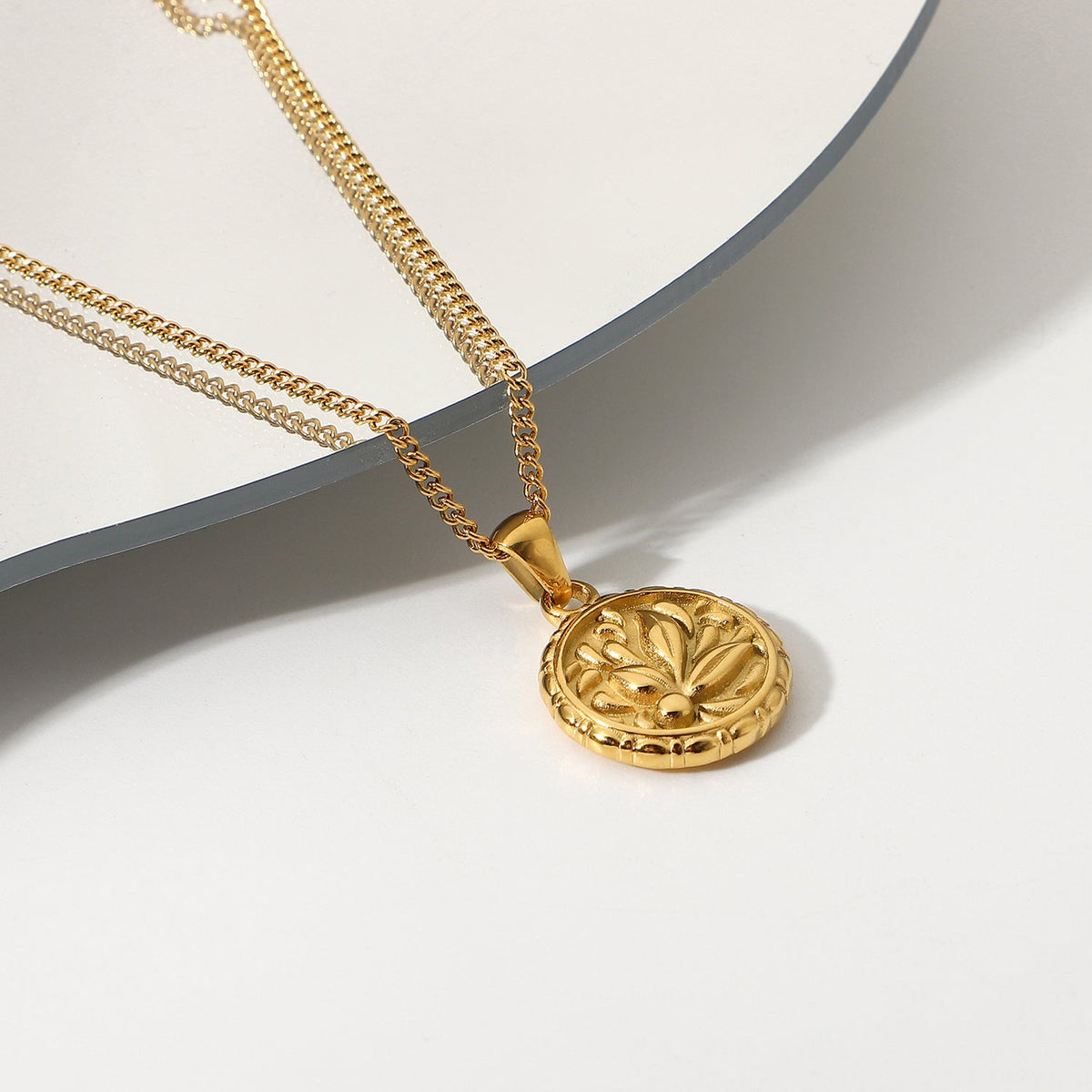 Colar Nummus dourado sobre fundo claro