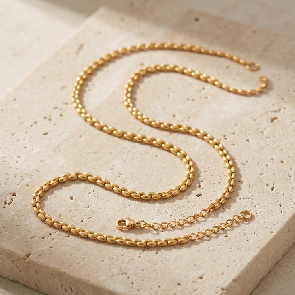 Colar Grana dourado sobre travertino