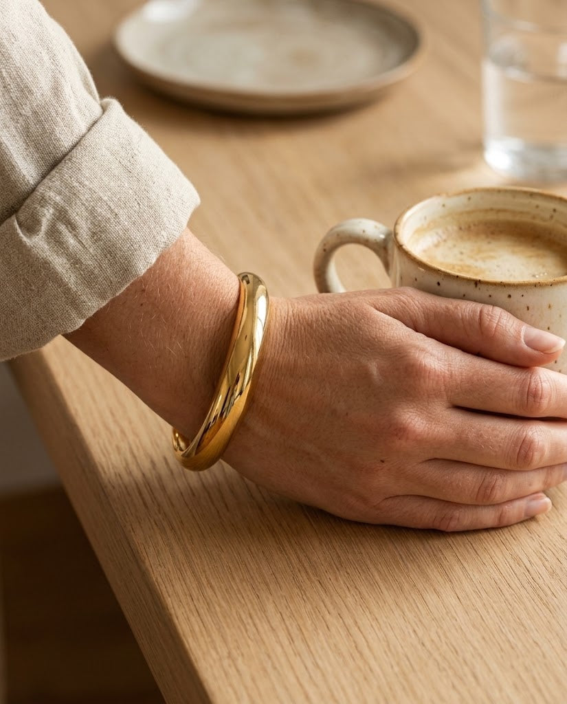 Pulseira Linea dourada no pulso de uma modelo