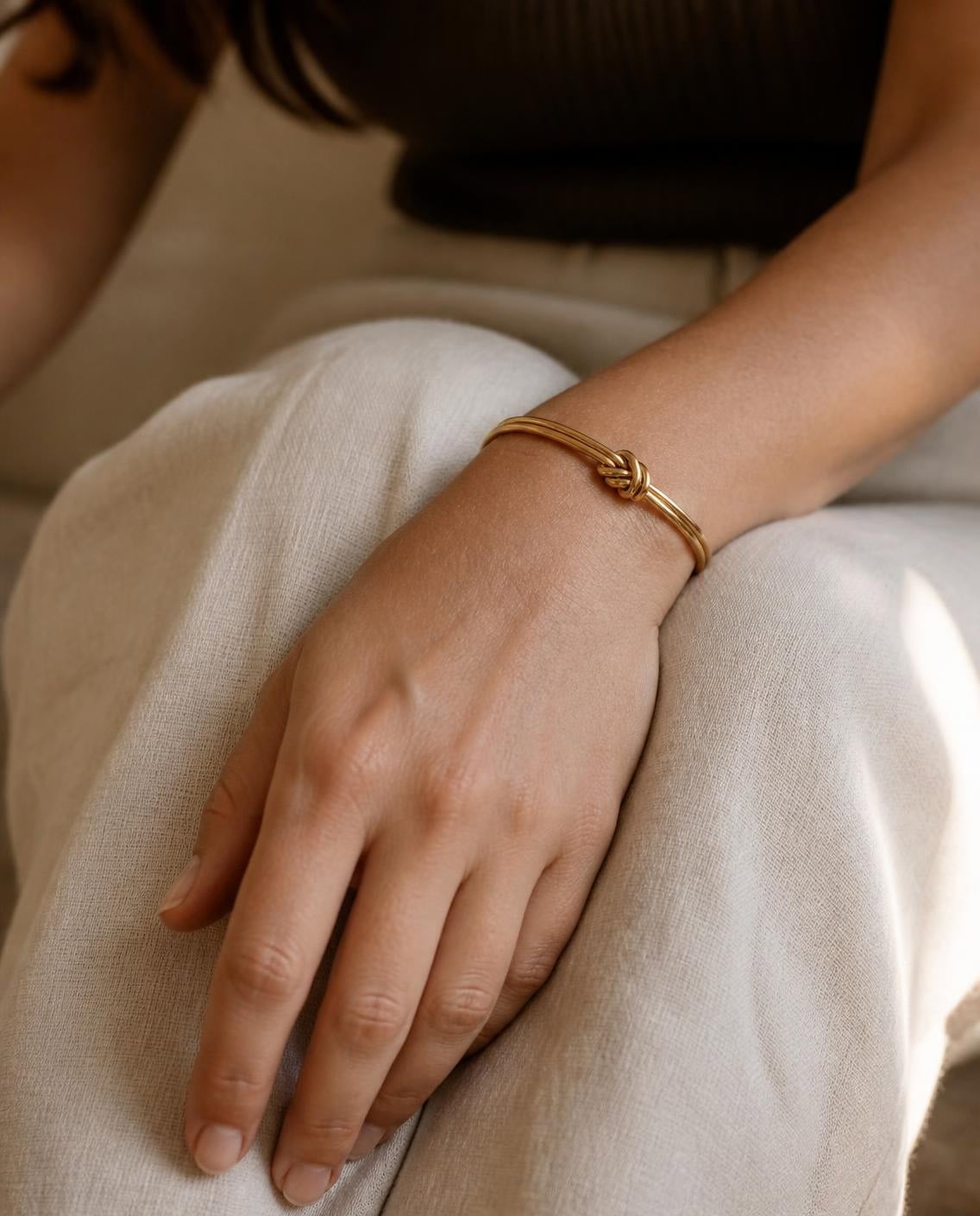 Pulseira Nodus dourada no pulso de uma modelo
